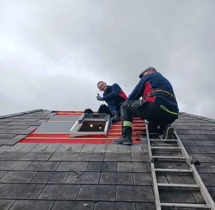 Recommended Roofing crew fitting a skylight into a slate roof